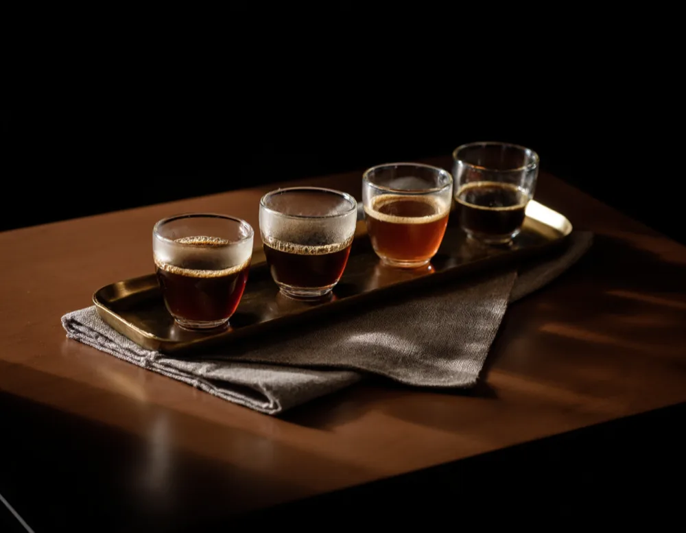 Four small glass cupping bowls on a dark walnut board